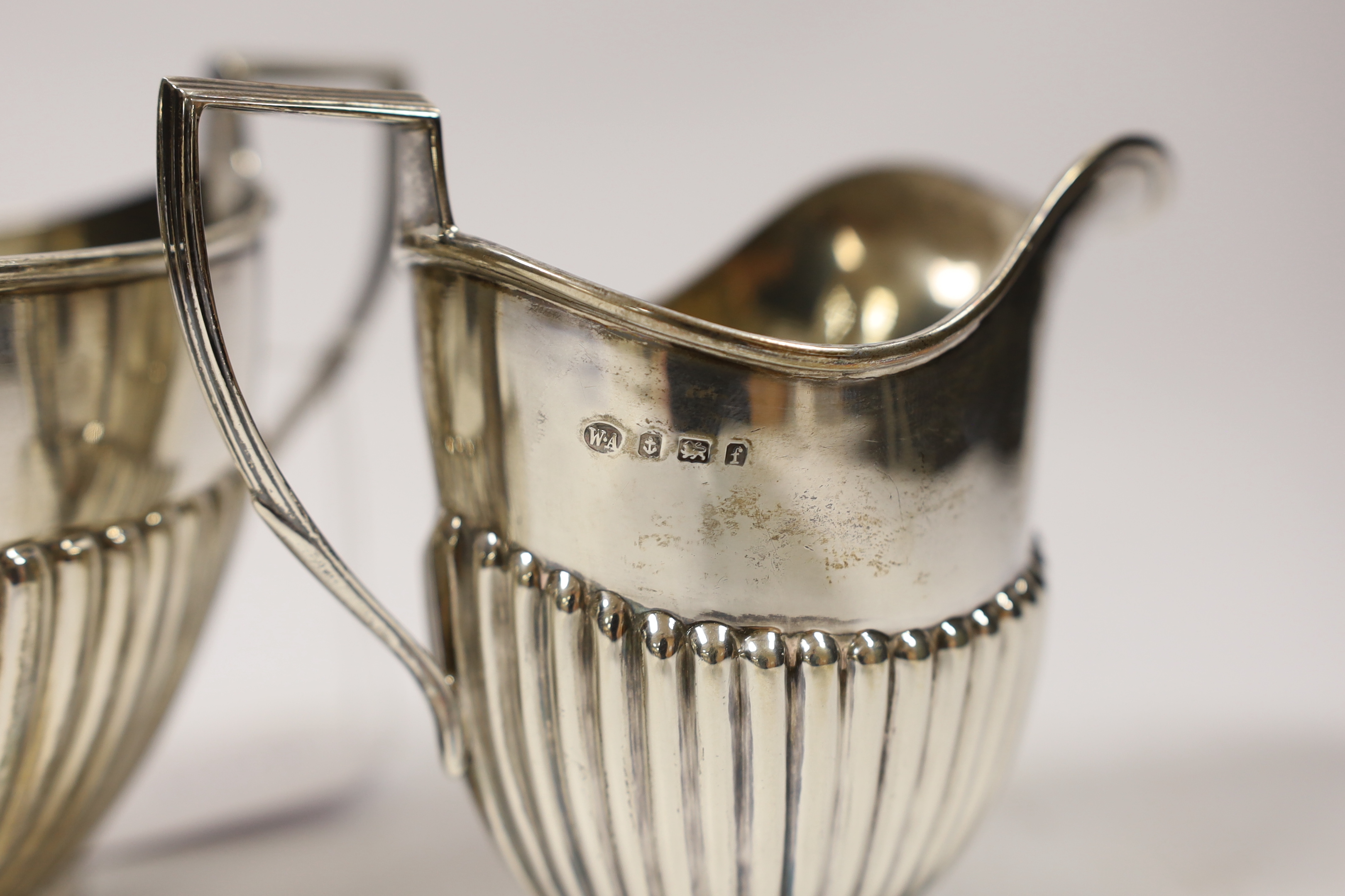 An Edwardian demi-fluted silver oval cream jug and sugar bowl, William Aitken, Birmingham, 1905